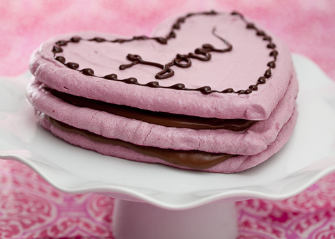 Top view of Pink heart shaped cake with chocolate glaze, meringues